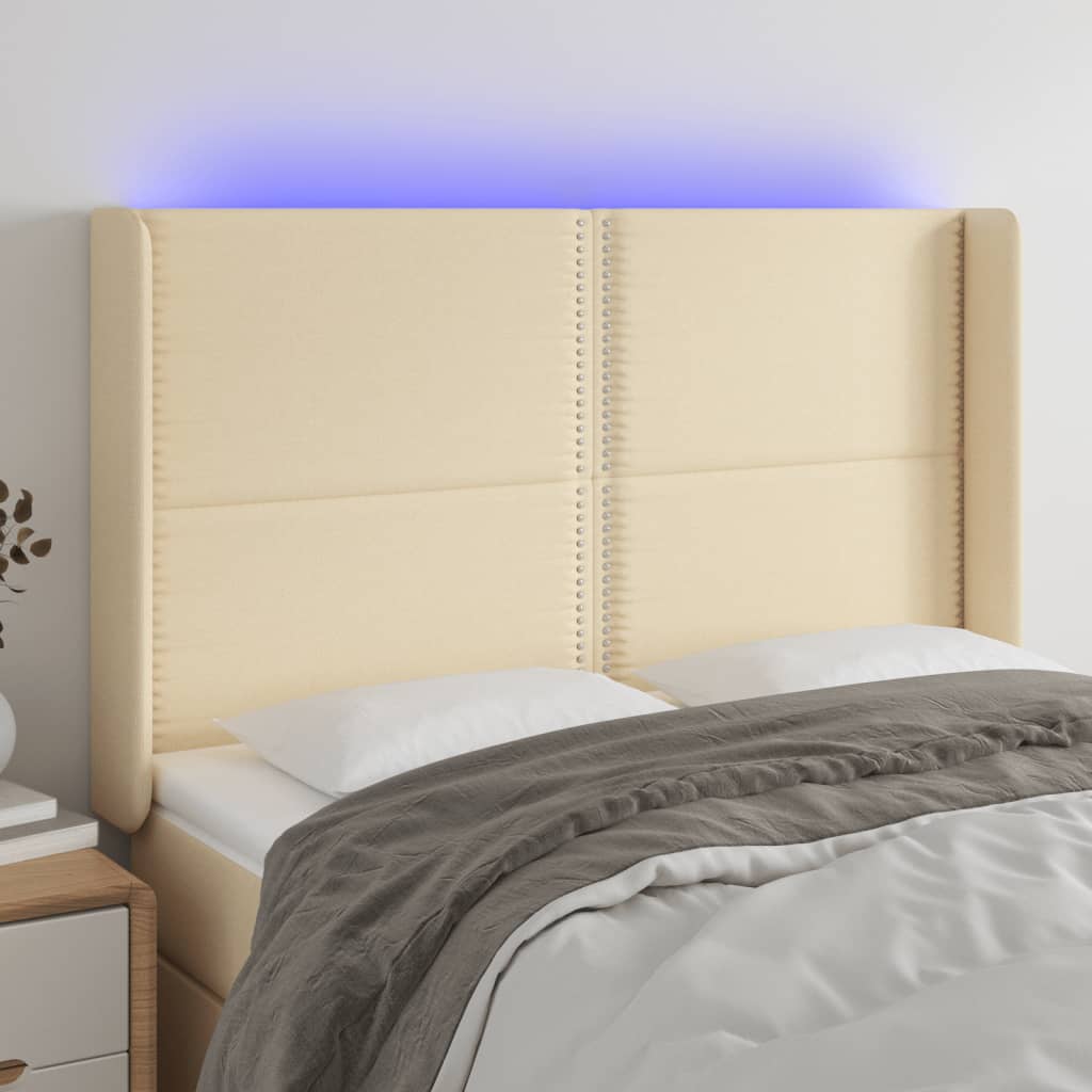 sengegavl med LED-lys 147x16x118/128 cm stof cremefarvet