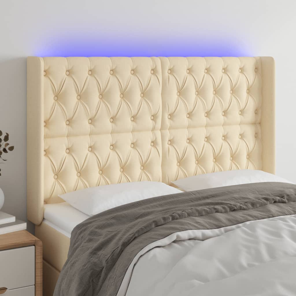 sengegavl med LED-lys 147x16x118/128 cm stof cremefarvet