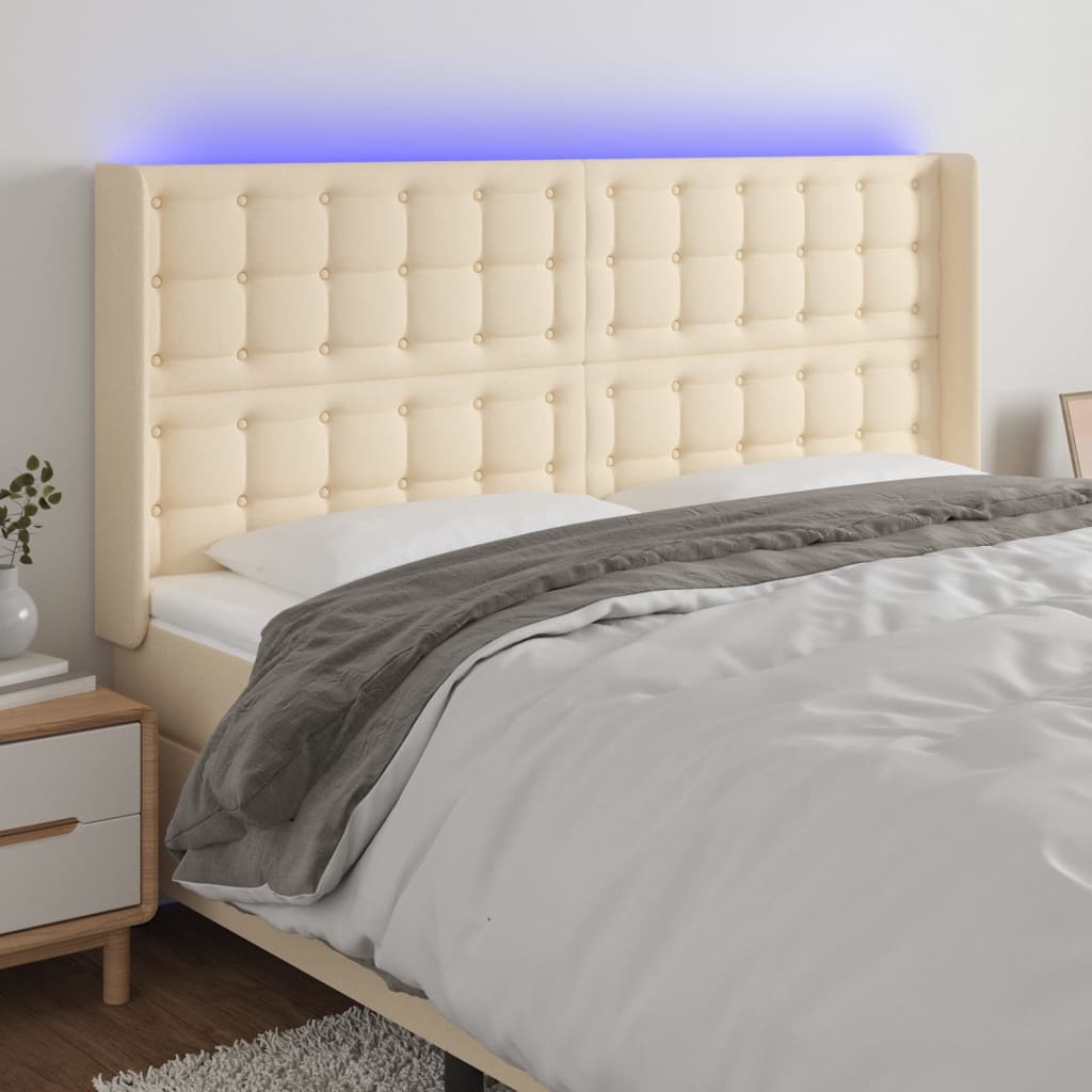 sengegavl med LED-lys 163x16x118/128 cm stof cremefarvet